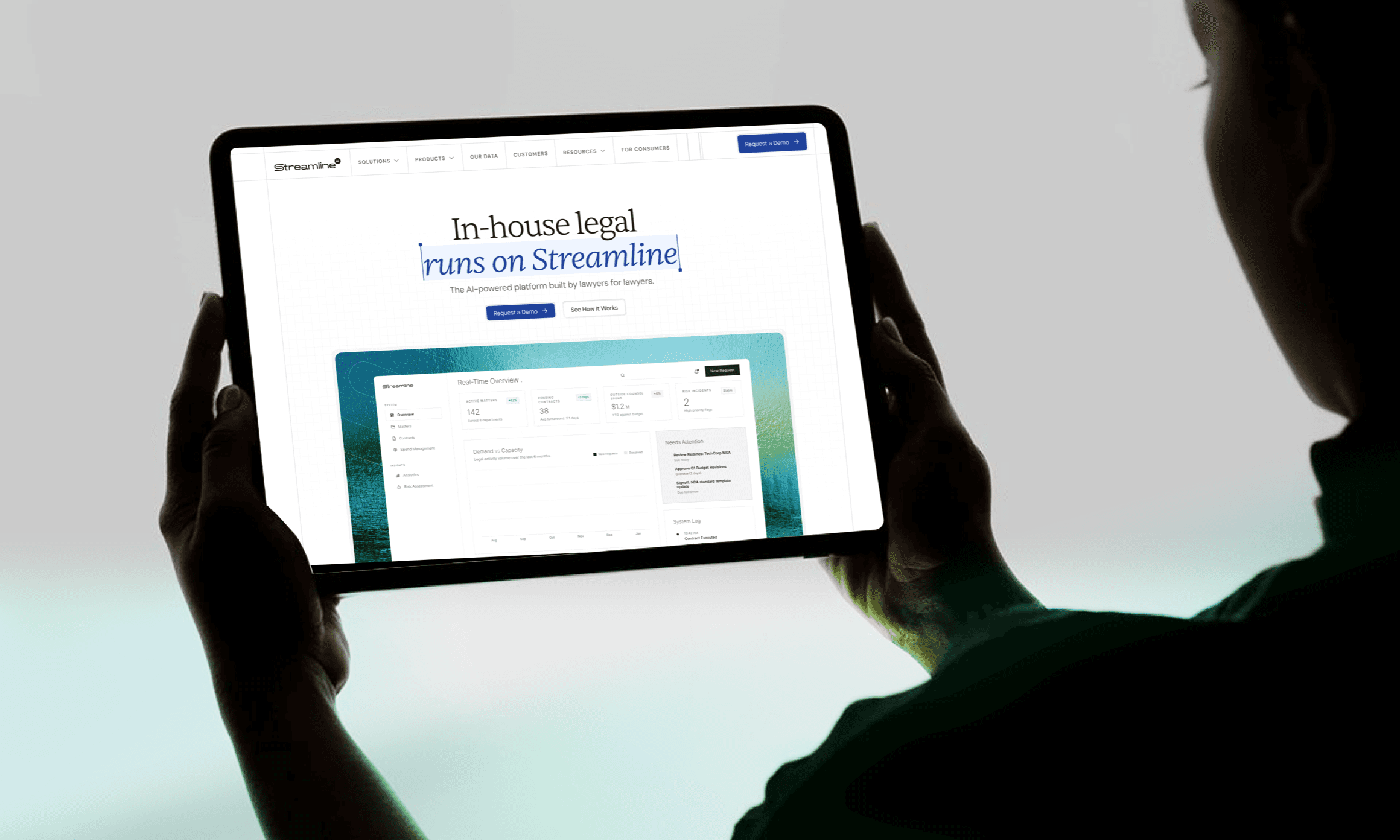Streamline homepage hero 'In-house legal runs on Streamline' on a tablet held in hands